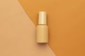 Beige plastic bottle of beauty skincare cosmetic mockup template on half beige and brown background.