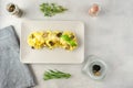 A beige plate with pasta with black truffle and parmesan stands on a grey concrete background. Near are herbs thyme, rosemary.