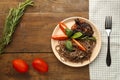 Beige plate soba with chicken tomatoes and spinach on a linen napkin with a fork, greens and tomatoes on the table.