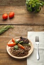 Beige plate soba with chicken tomatoes and spinach on a linen napkin with a fork, greens and tomatoes on the table.