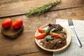 Beige plate soba with chicken tomatoes and spinach on a linen napkin with a fork beside greens and tomatoes