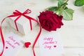 Beige polka dot gift box with red ribbon bow and bautiful red roses on wooden background. Greeting card for Mother`s day Royalty Free Stock Photo