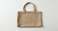 Beige, rectangular jute bag with two handles on a plain, light background. The texture Royalty Free Stock Photo