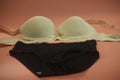 Beige seamless smooth women push up bra and black seamless smooth hipster panty.