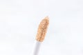 Beige skin concealer brush for makeup on light background close up with copy space.
