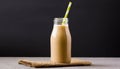 Beige smoothie in glass bottle with paper straw on table. Tasty drink Royalty Free Stock Photo