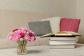 Beige sofa with plaid and colorful pillows pink, grey, white with books in the living room