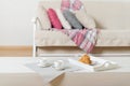 Beige sofa with plaid, colorful pillows pink, grey, white and coffee with croissantsin the living room