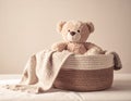 Beige Teddy Bear Sitting in Braided Basket with Soft Blanket in Studio Setting Royalty Free Stock Photo
