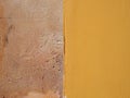 Beige textured limestone wall surface half painted in bright yellow Royalty Free Stock Photo