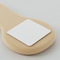 A beige textured object with a rounded handle shape, topped by a white, square flat Royalty Free Stock Photo