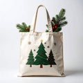 Beige Tote Bag with Christmas Tree Graphic and Evergreen Branches Royalty Free Stock Photo