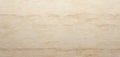 Beige travertine stone features natural linear patterns, subtle color variations. Cross-cut stone exhibits textured, matte Royalty Free Stock Photo