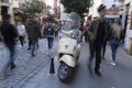 A beige Vespa Scooter at streets of Beyoglu, Istanbul and blurry people