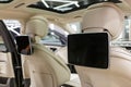 Beige white interior of a luxury Mercedes-Benz Maybach W223 S-class car with a wide-angle lens.