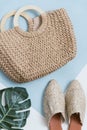 Beige wicker bag and mules on a pastel background. Wicker basket and shoes top view. Palm leaf and trendy and stylish accessories Royalty Free Stock Photo