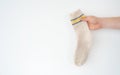 Beige woolen sock in hand