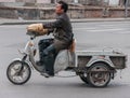 Man rides on freight tricycle in street, Beijing.