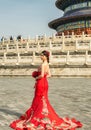 Pretty Chinese girl in red wedding dress in the Temple of Heaven in Beijing