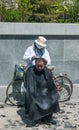 Ambulant barber with bike cuts hair, Beijing.