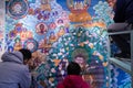 BEIJING, CHINA - DEC 22, 2017: Three chinese people painting a traditional buddhist wall art