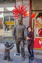 Portrait photo of Senior asian women with Selling Tang lu hu Chinese Famous local Food man statue in qianmen Street.Qianmen street