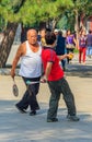 Elder couple playing Chinese game of Jianzi with a colorful feat