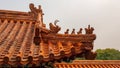 Beijing-A close up on the rooftop of a pavilion in Summer Palace in China. The roof has orange tiles and decorative small figures Royalty Free Stock Photo