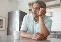 Being alone gets lonely. Shot of a senior man looking pensive while drinking coffee at home. Royalty Free Stock Photo