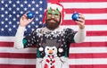 Being american can be fun. Bearded man have new year fun. Patriotic Santa on star spangled banner. Festive decor Royalty Free Stock Photo