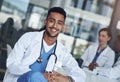 Being a doctor is my calling. a young male doctor taking a break from his rounds.