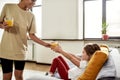 Being healthy. African american woman baby sitter entertaining caucasian cute little girl. Kid is sitting on the couch Royalty Free Stock Photo