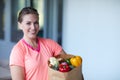 Being healthy is about what you eat. Portrait of a young attractive woman carrying a bag of groceries at home. Royalty Free Stock Photo