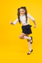 Being in a hurry. Active small child in formal wear rushing to school on yellow background. Happy girl leading active Royalty Free Stock Photo