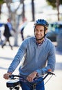 Being kind to the environment. a handsome man about to take a ride on his bicycle in the city. Royalty Free Stock Photo