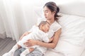 Being mom is so exhausted.  Tired mother laid in bed with newborn baby at night. Authentic real life exhausted parent taking rest Royalty Free Stock Photo