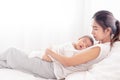 Being mom is so exhausted.  Tired mother laid in bed with newborn baby at night. Authentic real life exhausted parent taking rest Royalty Free Stock Photo