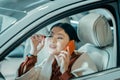 Busy woman putting on maskara on drivers seat. Royalty Free Stock Photo