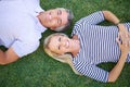 Being outdoors brings us closer together. High angle portrait of a mature couple lying in the park.