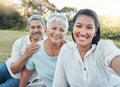 Being part of a family means smiling for photos. a woman taking a selfie with her parents in a park.