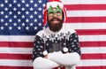 Being Santa can be fun. Bearded man enjoy new year fun. Patriotic hipster smile on star spangled banner. Festive decor Royalty Free Stock Photo