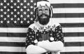 Being Santa can be fun. Bearded man enjoy new year fun. Patriotic hipster smile on star spangled banner. Festive decor Royalty Free Stock Photo