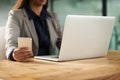 Being successful means staying connected. an unrecognisable businesswoman using a cellphone and laptop in an office.