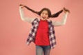 Being such a good girl. Pigtailed little girl pink background. Happy girl hold long hair. Small girl smile in casual