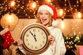 Being surprised. xmas mood. Woman wi clock. winter holidays. Its time for christmas. girl in red santa claus hat Royalty Free Stock Photo