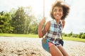 Being young means having nothing but days of fun. a young girl playing on a swing at the park.