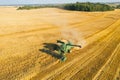 Belarus - 30 August. Green farm combine harvester harvests ripe yellow wheat on farm. Harvesting of field with combine