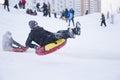 Belarus, the city of Gomel, January 07, 2018.Central Park.Child sledding cheesecake.Sledding off a snow slide.A boy on a sled Royalty Free Stock Photo