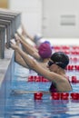 Women swimmers in a swimming hat and goggles on the background of the pool