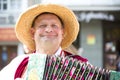 Holiday City Day. Central Park.A man in a straw hat playing the harmonica.